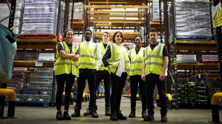 A group of warehouse workers wearing hi vis vests