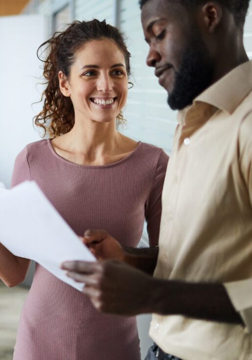 Staff Australia Employment Services 6 A recruitment consultant is filling out some documents in an office hallway with a male candidate.