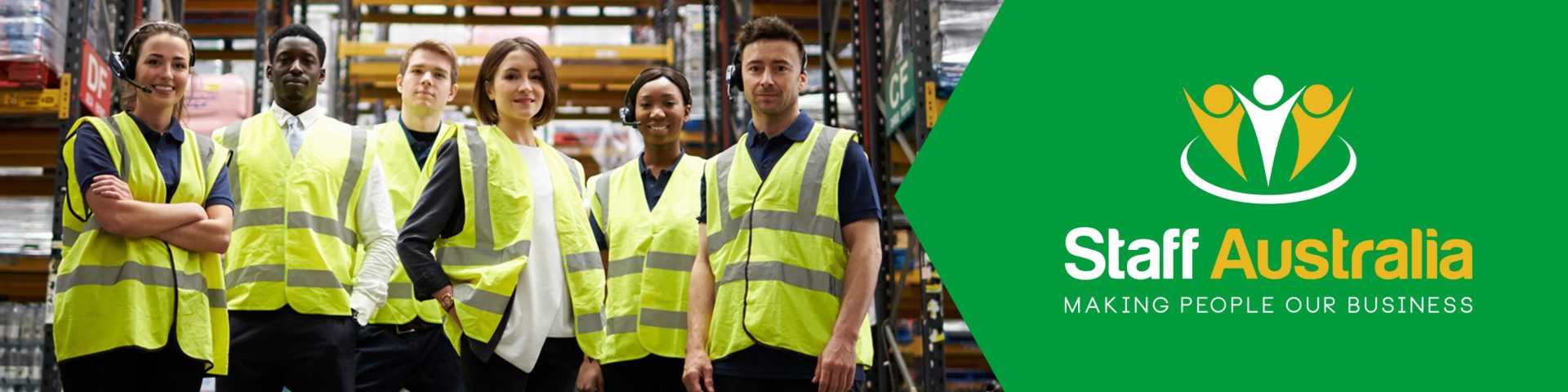 A group of young workers in a warehouse wearing safety jackets.