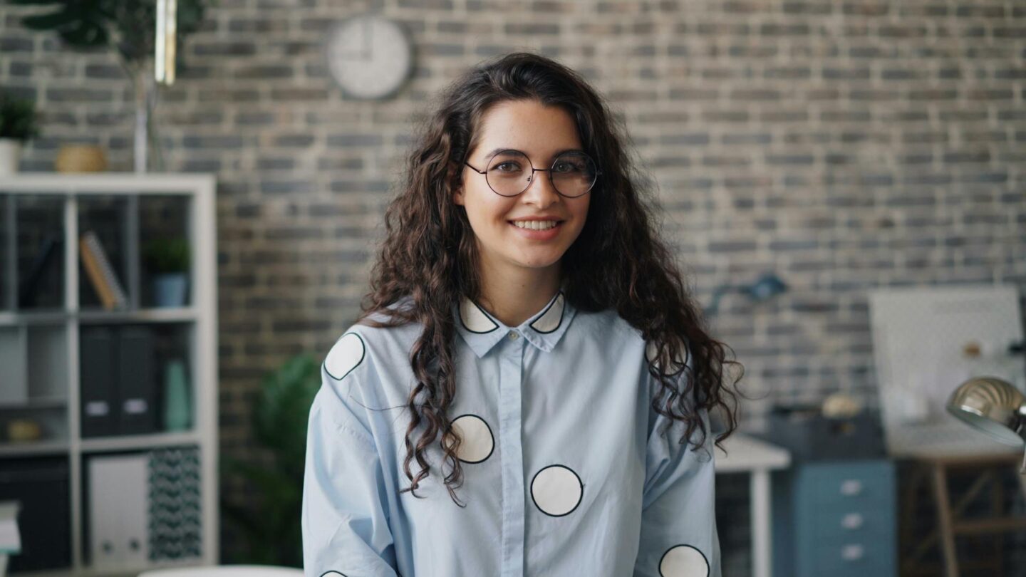 A young woman in an office, looking professional and focused.