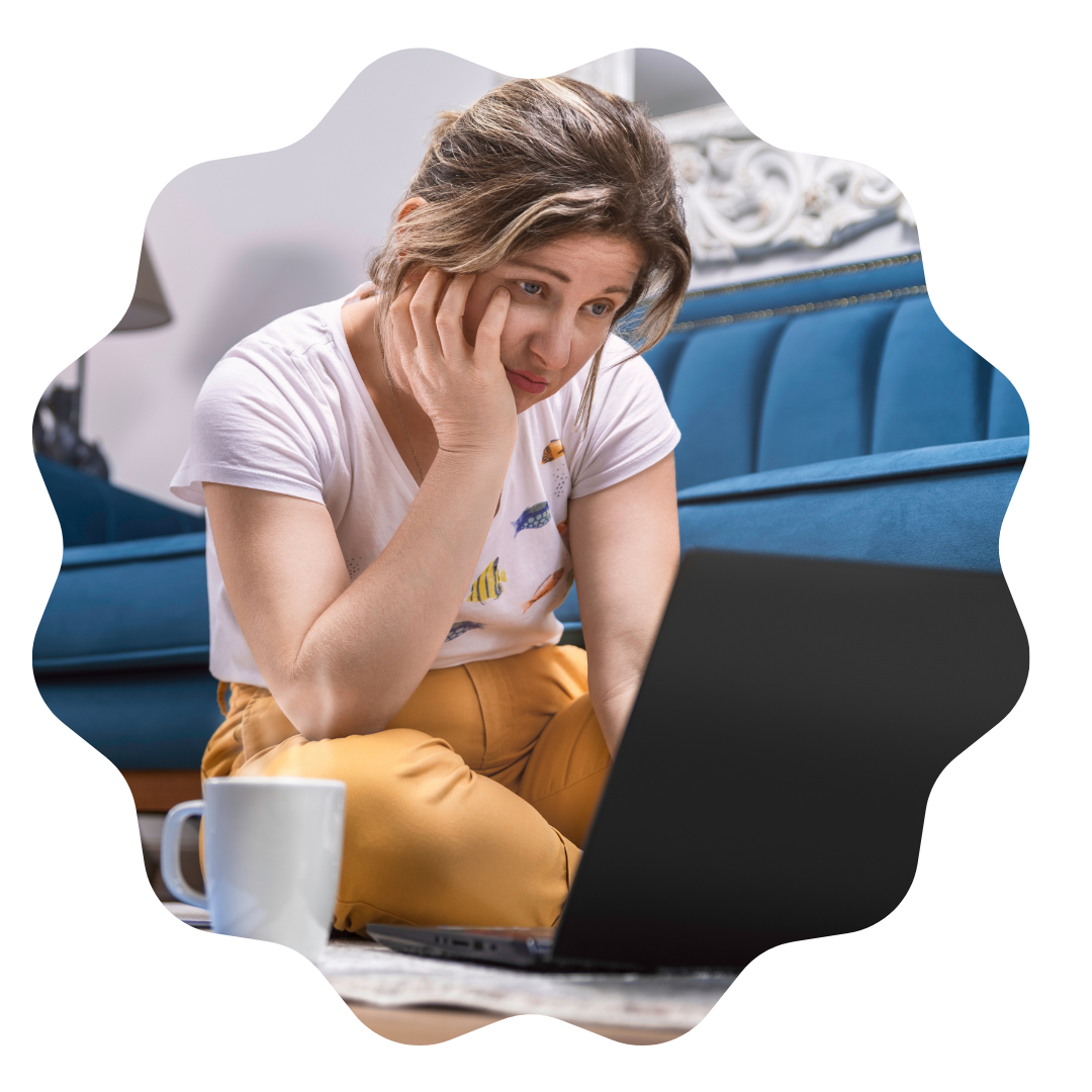 The Power of Persistence: How to Handle Job Rejection in 5 Steps 1 A woman is sitting on the floor looking at her laptop with a defeated look on her face as she looks for a job