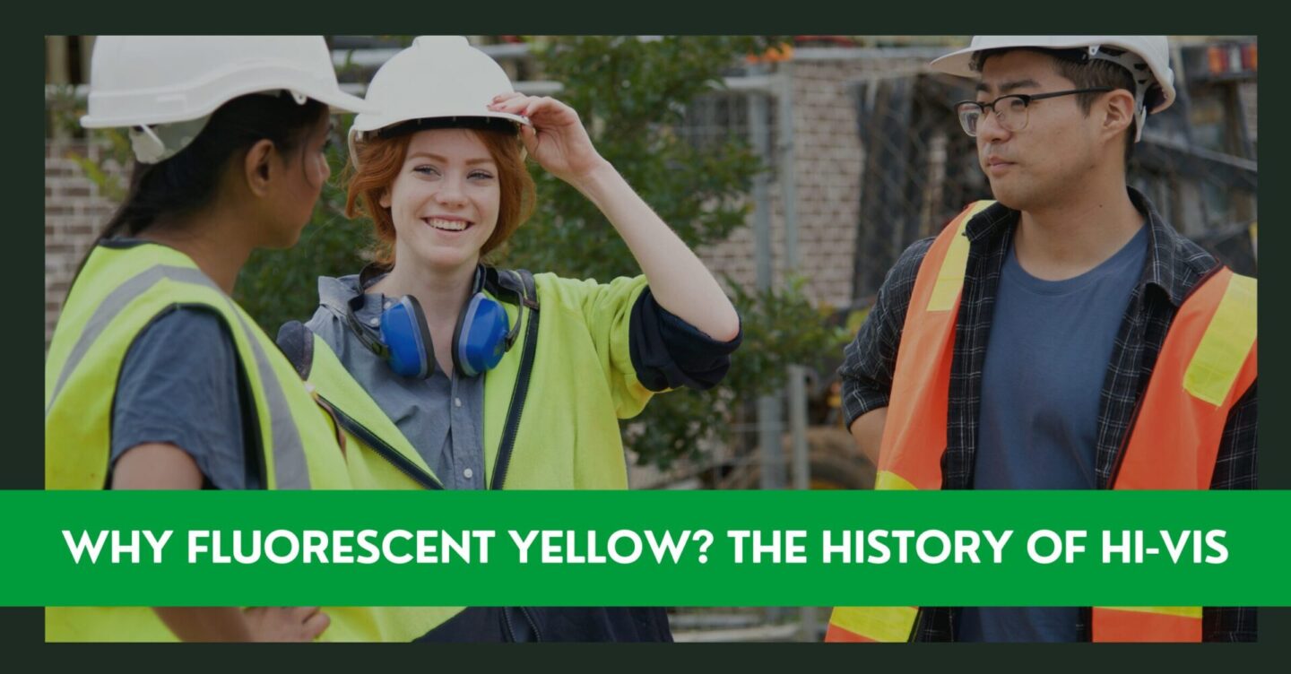 three young construction workers wearing high visibility vests are smiling and talking to each other